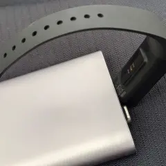 Smartband podłączony do powerbanka, pokazujący, jak ładować smartwatch bez ładowarki.