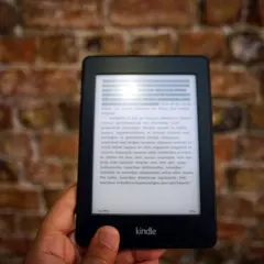 Dłoń trzyma czytnik Kindle z tekstem. Komputer nie widzi Kindla, mimo że jest podłączony.