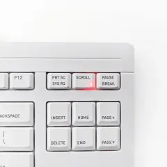 Biała klawiatura z podświetloną na czerwono diodą przy klawiszu SCROLL LOCK. Klawisz PAUSE/BREAK obok.