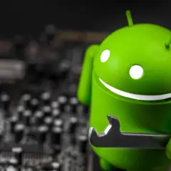 Zielony robot Android z kluczem, jakby wykryto nakładkę ekranową. W tle widać rozmazaną płytę główną.