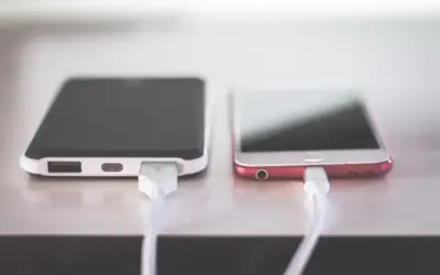 Dwa telefony podłączone do ładowania. Zastanawiasz się, dlaczego telefon wolno się ładuje? Może to wina kabla lub ładowarki.