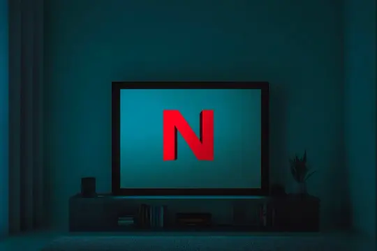 Ciemny pokój, na ekranie telewizora czerwone logo Netflix. Niestety, Netflix nie działa na TV, co frustruje widza.