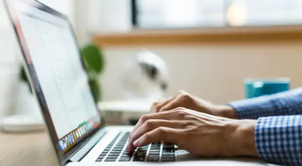 Dłonie piszą na laptopie, ekran wyświetla dane, być może związane z wmi provider host.