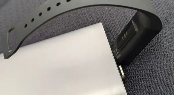 Smartband podłączony do powerbanka, pokazujący, jak ładować smartwatch bez ładowarki.