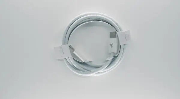 Biały kabel USB C, zwinięty w okrąg, z widocznymi złączami. Opis żył tego kabla jest kluczowy dla jego funkcjonalności.