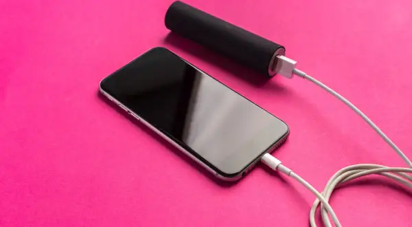Telefon ładuje się z powerbanku. To sposób, jak naładować telefon bez ładowarki, gdy jesteś w podróży.