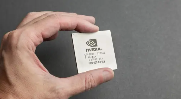 Dłoń trzyma procesor graficzny NVIDIA. Jeśli masz problemy z grafiką, dowiedz się, jak zresetować sterowniki karty graficznej.