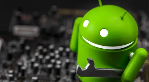 Zielony robot Android z kluczem, jakby wykryto nakładkę ekranową. W tle widać rozmazaną płytę główną.
