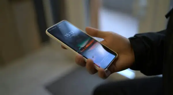 Dłoń trzyma smartfon Samsung. Chcesz wiedzieć, jak wyłączyć dźwięk klawiatury Samsung?