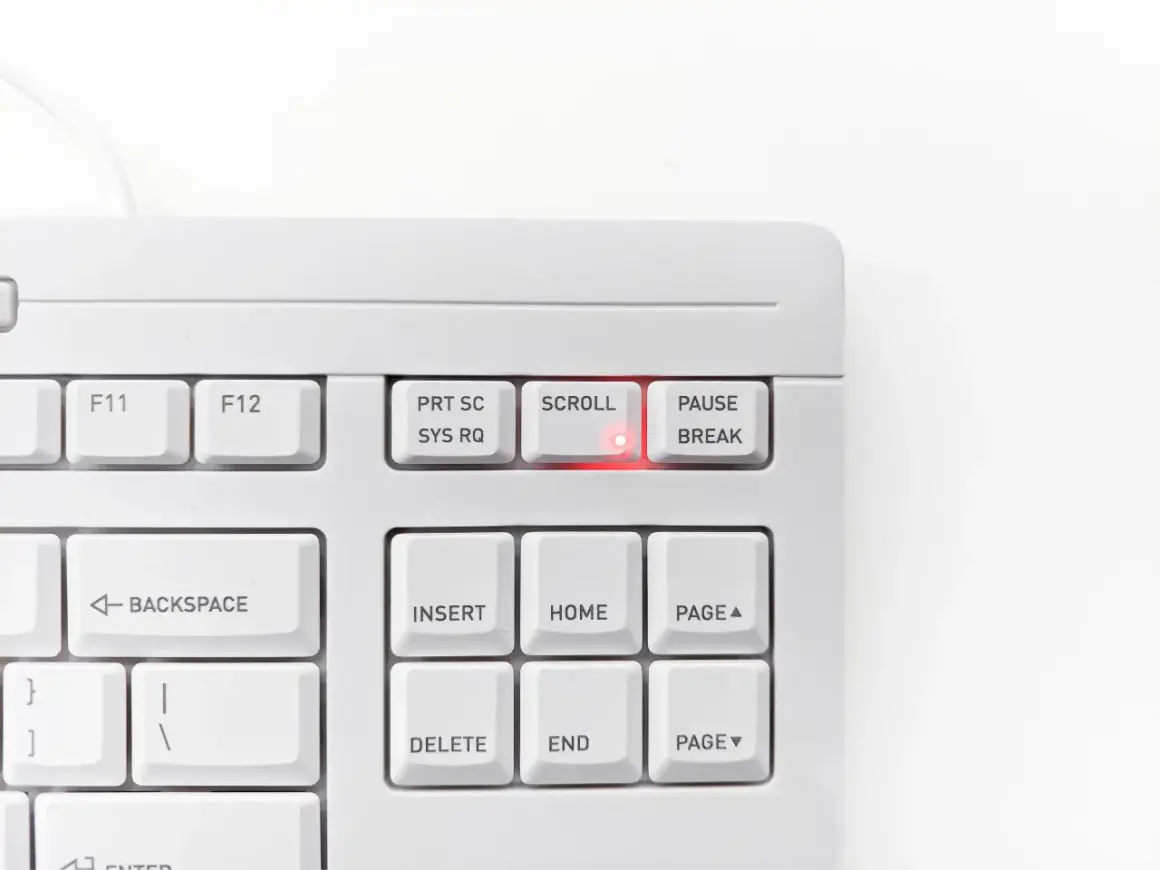 Biała klawiatura z podświetloną na czerwono diodą przy klawiszu SCROLL LOCK. Klawisz PAUSE/BREAK obok.