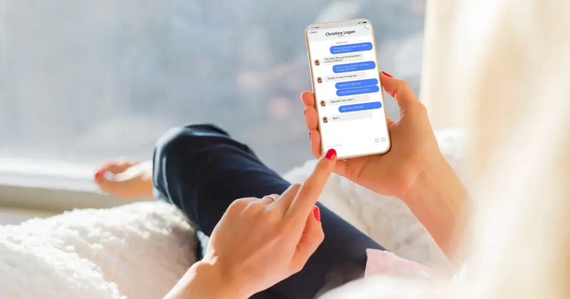Dłoń trzyma smartfon z rozmową na Messengerze. Można tu zobaczyć, jak być niewidocznym na Messengerze, ale widzieć innych, gdy ekran pokazuje status "online" u rozmówcy.