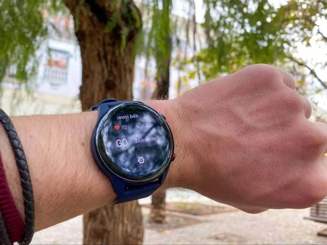 Na nadgarstku widać smartwatch mi watch revolve, gotowy do biegu. Na ekranie widnieje tętno 72, GPS i napis