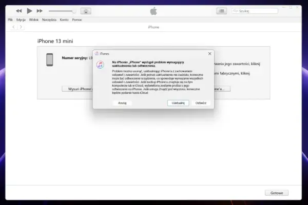 Komunikat w iTunes informuje o problemie z iPhone'em 13 mini, sugerując uaktualnienie lub odtworzenie, co jest kluczowe, jak odblokować iPhone w takiej sytuacji.
